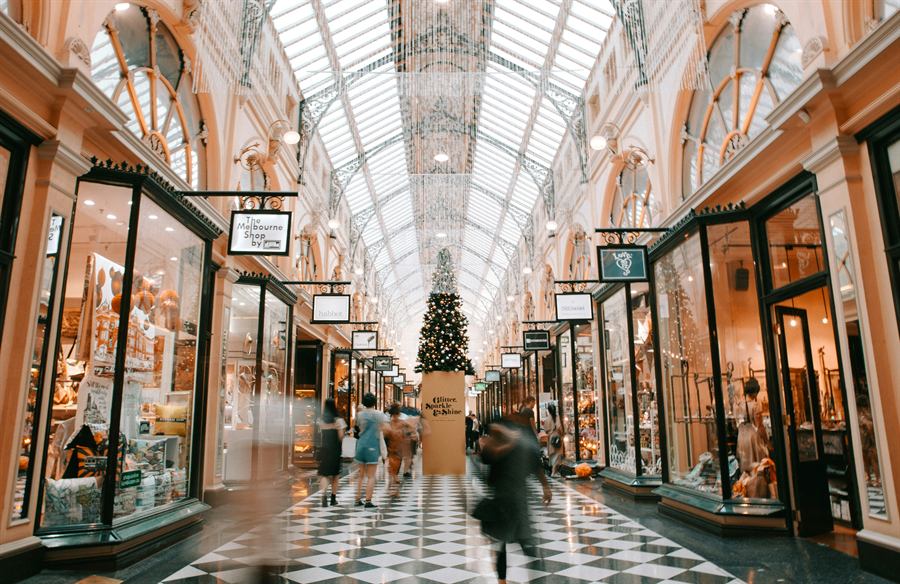 Galerie marchande animée avec vitrines de boutiques, illustrant le commerce de détail.