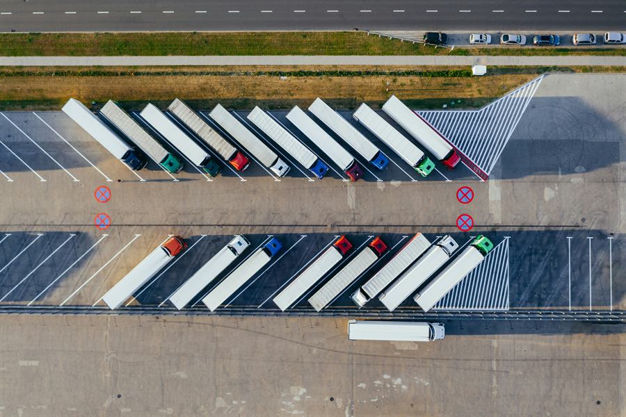 Vue aérienne de camions de transport stationnés dans un centre logistique.